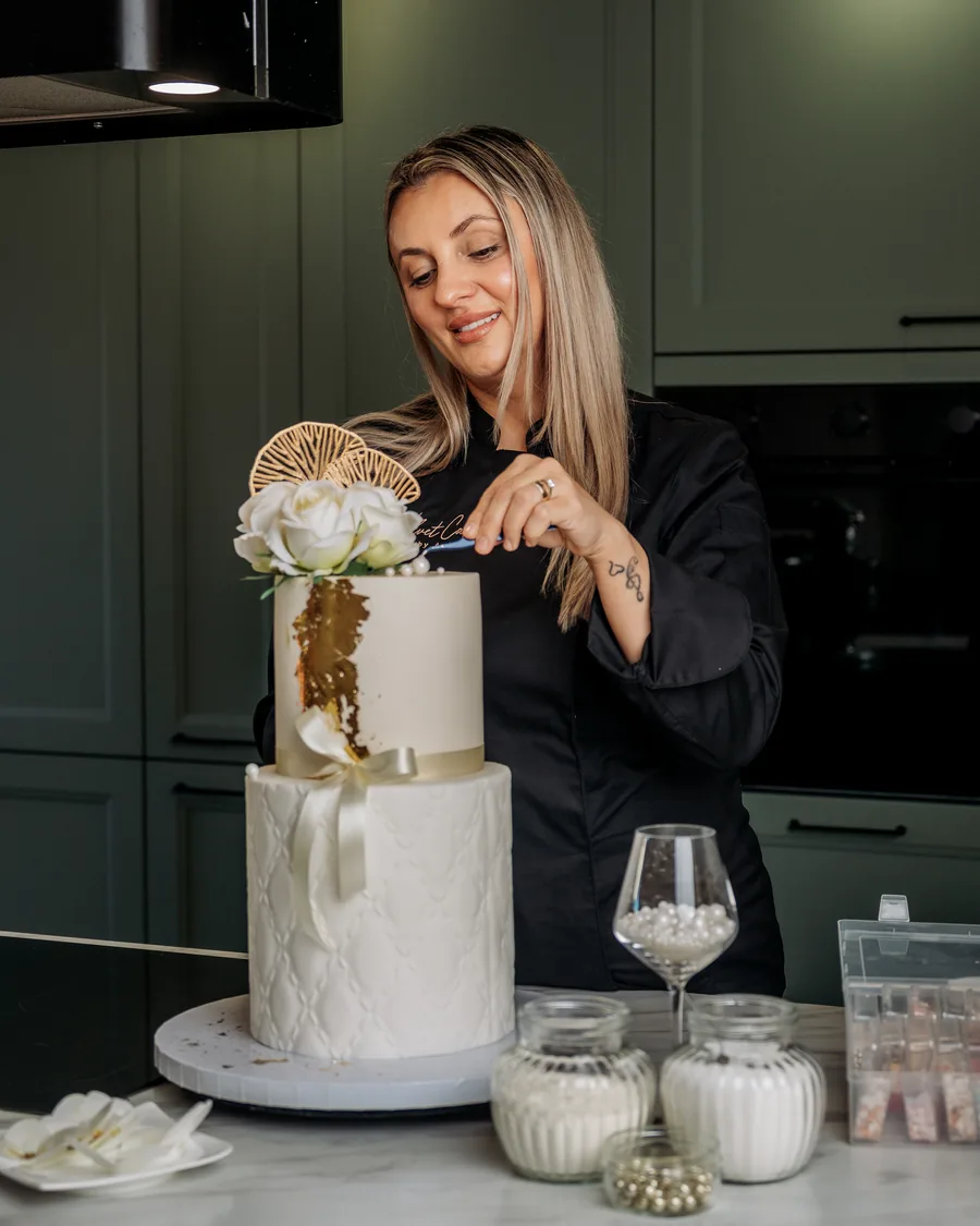 Anka zet de bloemen op een bruidstaart