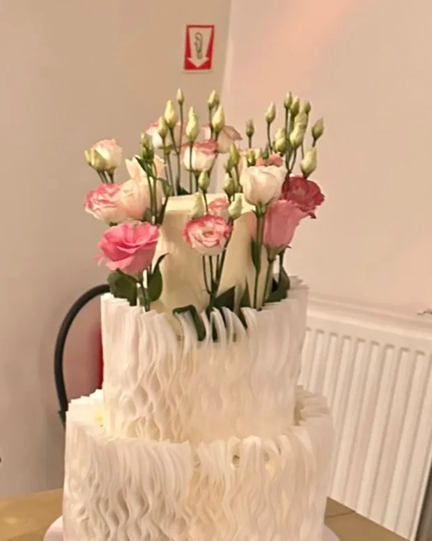 Two-tier ruffle cake with lisianthus and roses