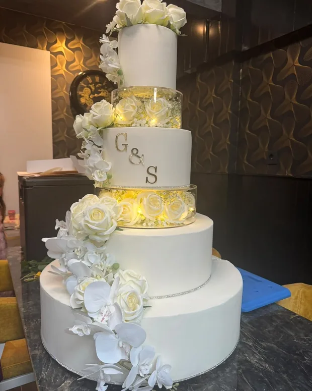 Four-tier wedding cake with roses and orchids