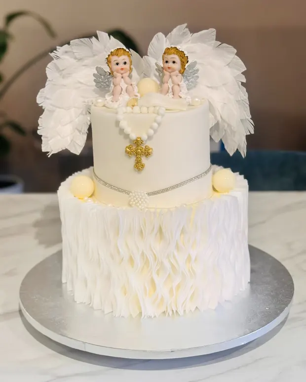 White christening cake with angels and a gold cross