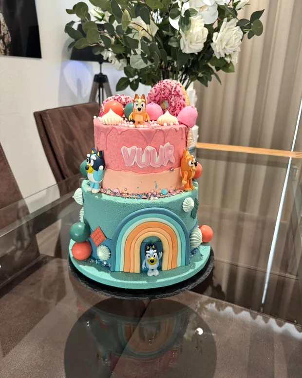 Two-tier cake with a rainbow and puppies