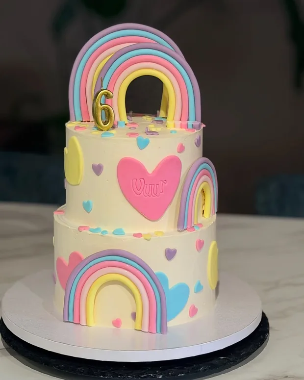 Two-tier cake with rainbows and hearts