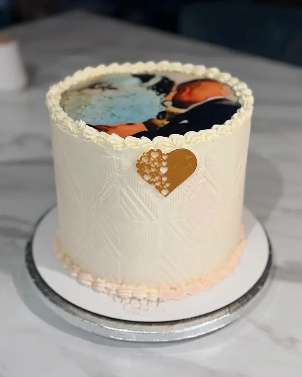 White cake with a gold heart and photo
